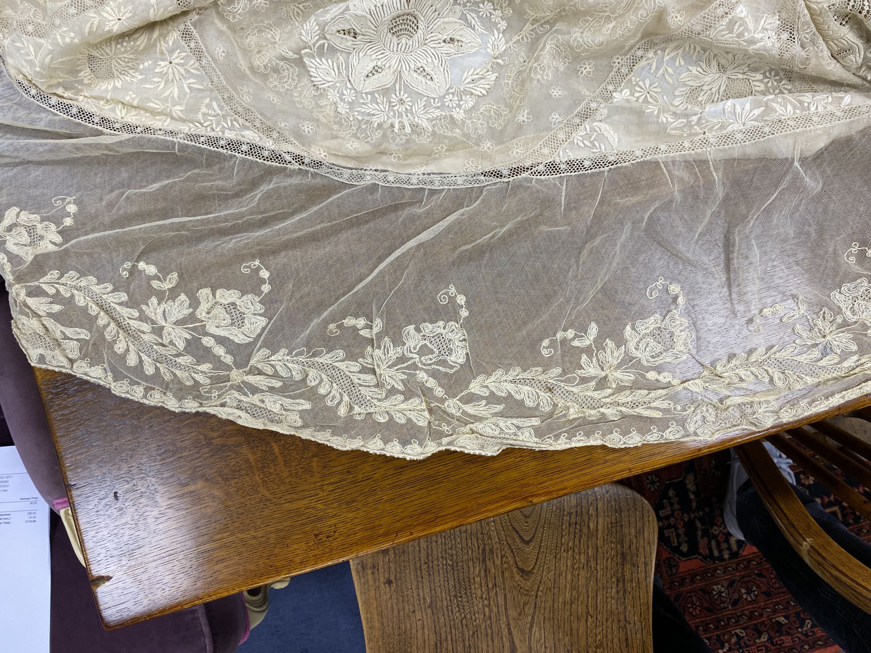 An Edwardian hand made lace bedspread. Hand sewn using finely spun lawn, decorated with Carrickmacross and white work embroidery, edged in bobbin lace. Possibly made as part of a trousseau.